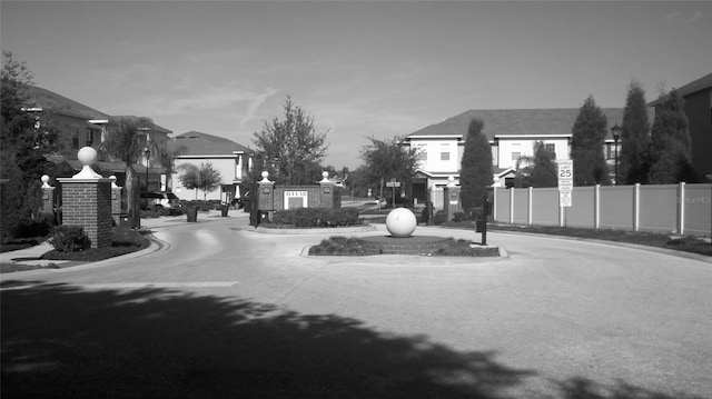 view of street with a residential view, traffic signs, curbs, and street lights