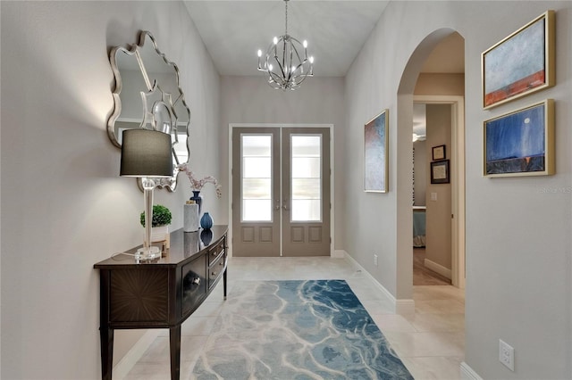 6507 Maiden Sea Dr, Apollo Beach, FL 33572 - foyer featuring light tile patterned flooring, a notable chandelier, arched walkways, french doors, and baseboards