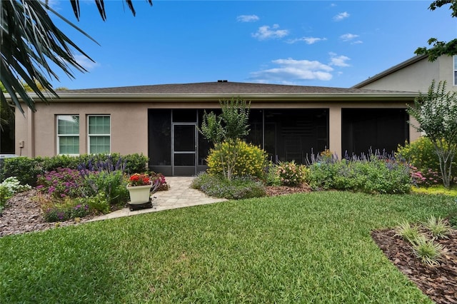 6507 Maiden Sea Dr, Apollo Beach, FL 33572 - rear view of house featuring a lawn, a sunroom, and stucco siding