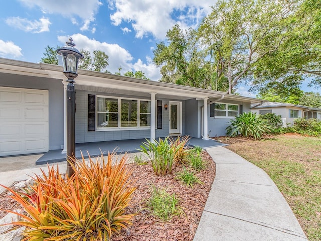 single story home featuring a porch and an attached garage