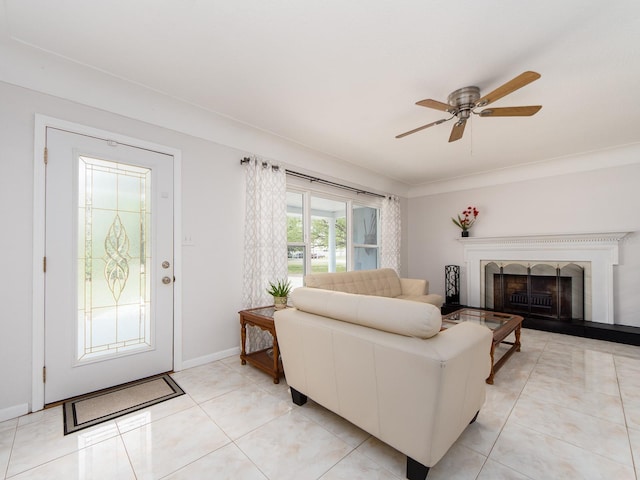 living area featuring baseboards, a ceiling fan, a fireplace with raised hearth, and light tile patterned floors