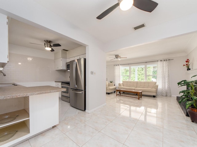 kitchen with open floor plan, ceiling fan, appliances with stainless steel finishes, and a sink