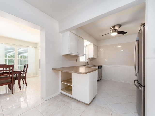 kitchen with white cabinets, open shelves, appliances with stainless steel finishes, a ceiling fan, and light tile patterned floors