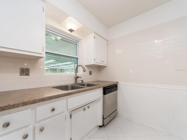 kitchen with a sink, dishwasher, white cabinetry, light tile patterned floors, and tasteful backsplash