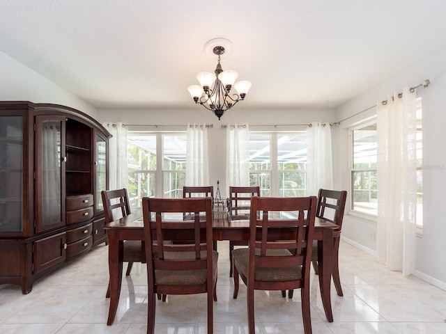 dining area featuring baseboards, an inviting chandelier, plenty of natural light, and light tile patterned floors