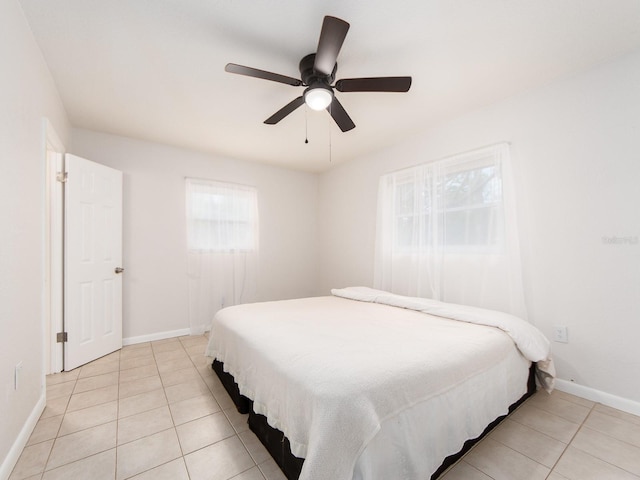 bedroom featuring a ceiling fan, baseboards, and light tile patterned floors