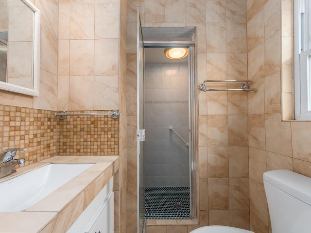 bathroom featuring vanity, tile walls, a shower stall, and toilet