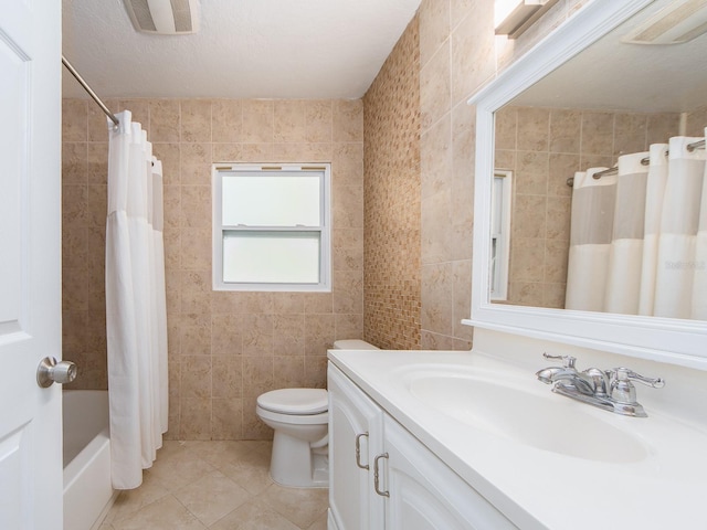bathroom featuring visible vents, tile patterned floors, toilet, and tile walls