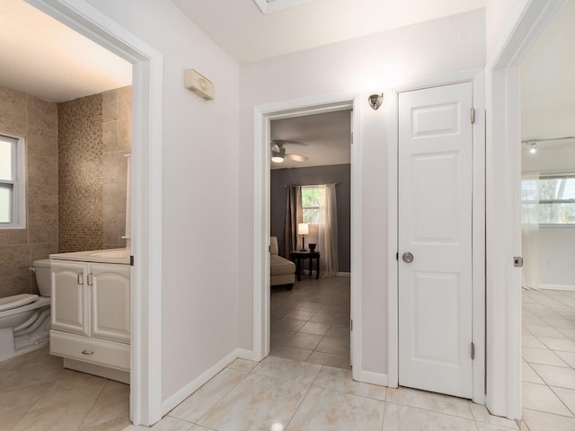 corridor featuring light tile patterned floors and a wealth of natural light