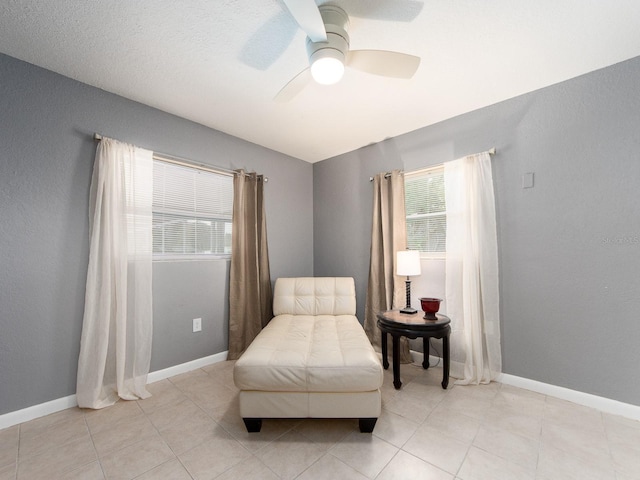 living area with plenty of natural light, ceiling fan, and light tile patterned flooring
