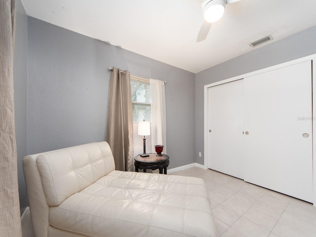 bedroom featuring a ceiling fan, baseboards, light tile patterned floors, visible vents, and a closet