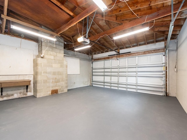 garage featuring a garage door opener and concrete block wall
