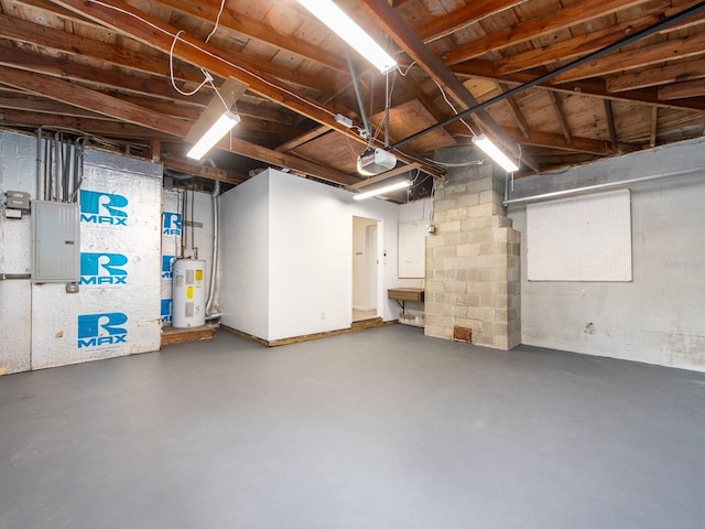 unfinished below grade area with electric panel and electric water heater