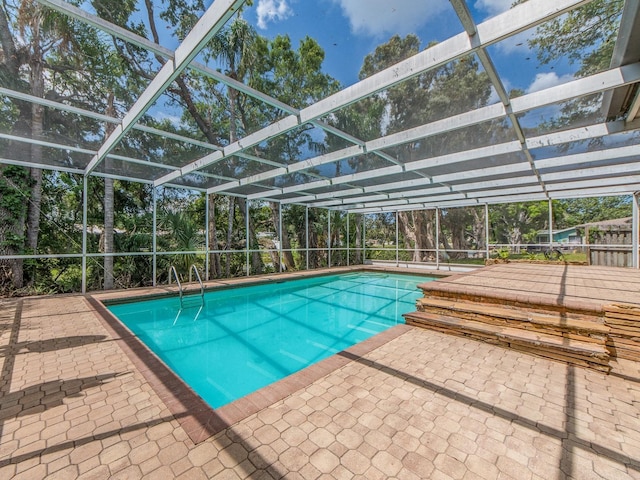 outdoor pool with a patio and glass enclosure