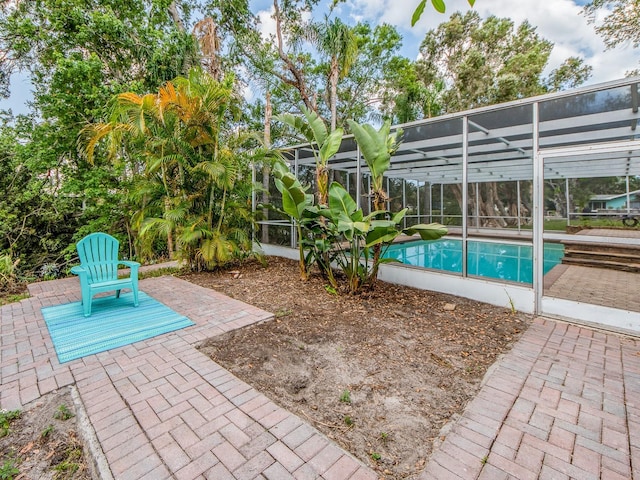 pool featuring glass enclosure and a patio area