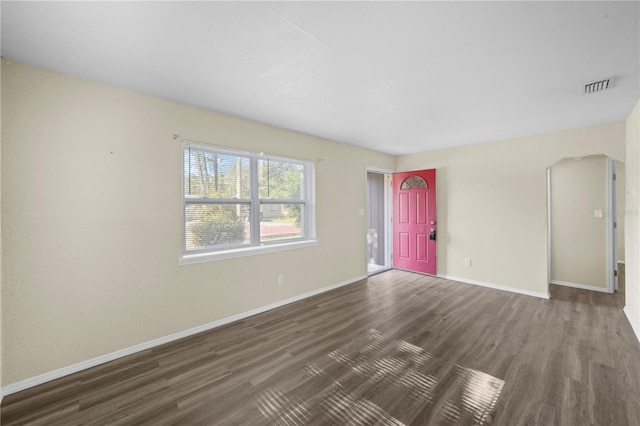 unfurnished living room with baseboards, visible vents, and wood finished floors