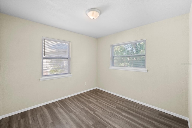 unfurnished room featuring dark wood finished floors and baseboards
