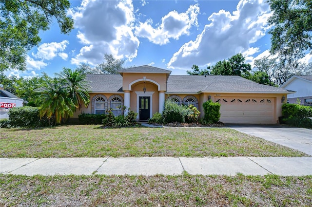 2117 Laindale Pl, Valrico, FL 33596 - mediterranean / spanish-style house featuring an attached garage, stucco siding, driveway, and a front lawn
