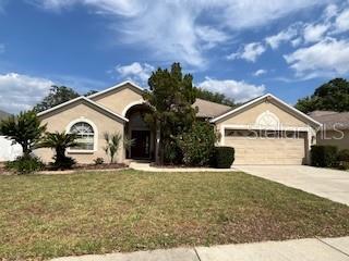ranch-style home with driveway, a front yard, and a garage