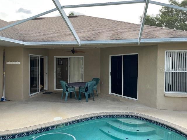 back of property with roof with shingles, stucco siding, a patio area, a ceiling fan, and a lanai