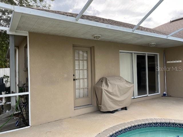 exterior space featuring glass enclosure, a patio area, and area for grilling