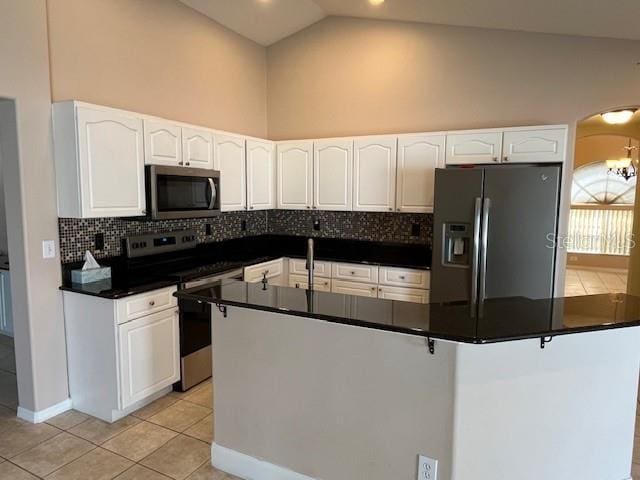 kitchen featuring backsplash, stainless steel appliances, dark countertops, and light tile patterned floors