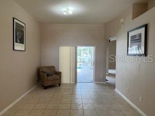 unfurnished room featuring baseboards and light tile patterned floors