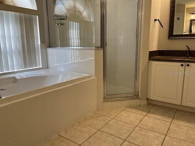 full bathroom with a garden tub, tile patterned flooring, a stall shower, and vanity