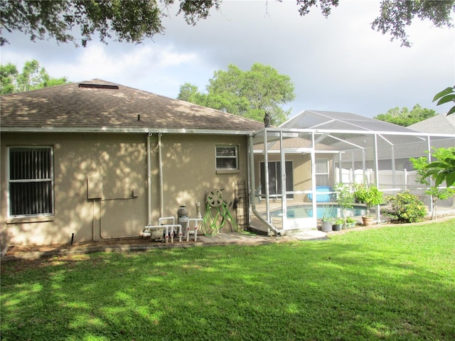 2213 Towering Oaks Cir, Seffner, FL 33584 - rear view of house with a shingled roof, stucco siding, an outdoor pool, and a yard
