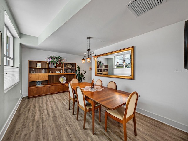 dining room featuring wood finished floors, baseboards, and a chandelier