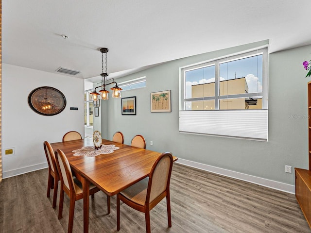 dining room with wood finished floors, baseboards, and a chandelier