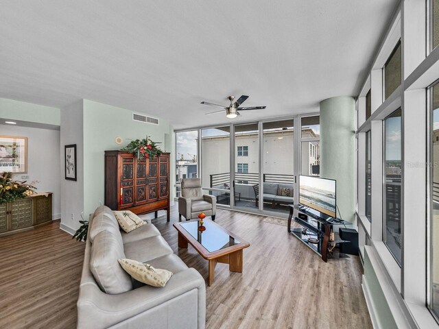 living room with wood finished floors, ceiling fan, and expansive windows