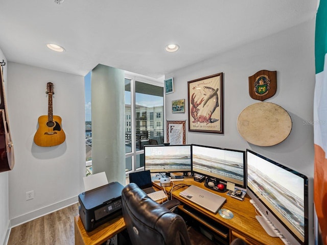 office area with wood finished floors, baseboards, recessed lighting, and expansive windows
