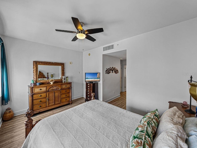 bedroom with wood finished floors, a ceiling fan, and baseboards