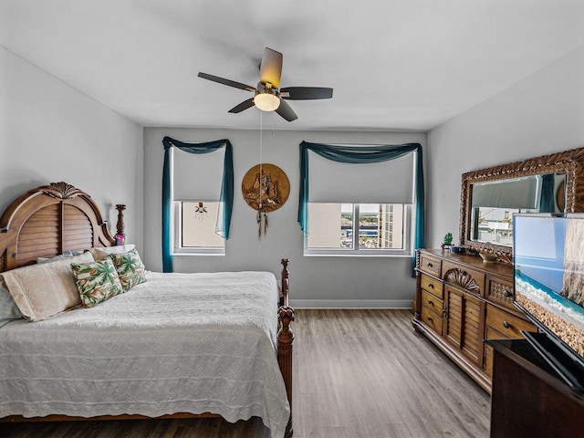 bedroom featuring wood finished floors, baseboards, and ceiling fan