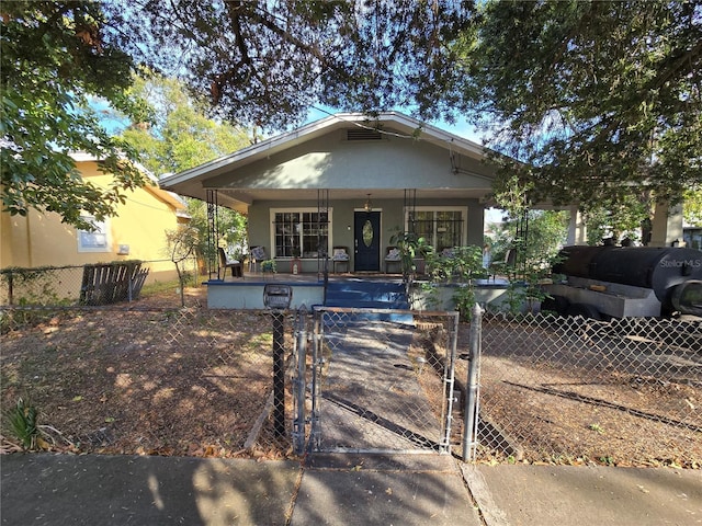 bungalow-style home with a gate, a fenced front yard, and covered porch