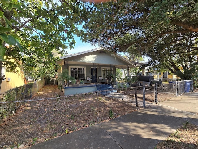 bungalow-style house featuring a gate, a fenced front yard, and covered porch