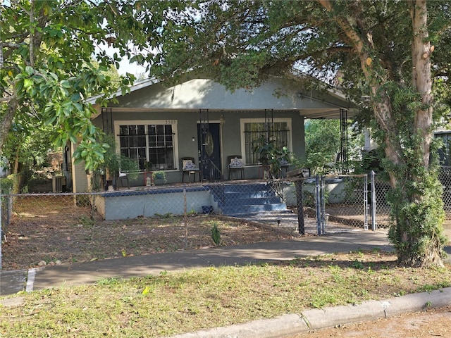 bungalow-style house featuring a porch, a gate, a fenced front yard, and stucco siding
