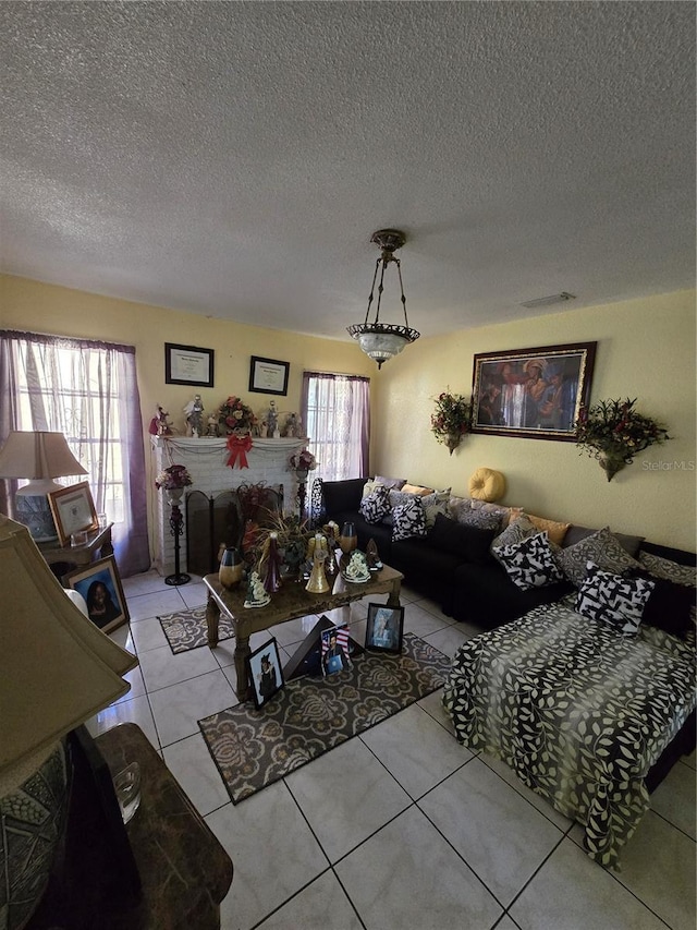 living area featuring visible vents, a textured ceiling, and light tile patterned flooring