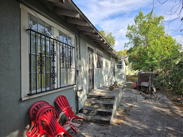 view of side of home featuring a patio and stucco siding