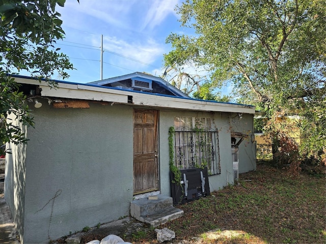 view of side of property featuring entry steps and stucco siding