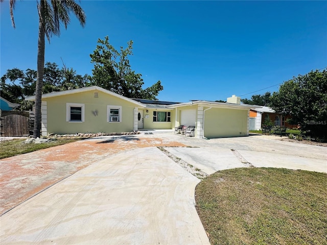 1101 Alcazar Way S, Saint Petersburg, FL 33705 - ranch-style house with fence, stucco siding, solar panels, and driveway