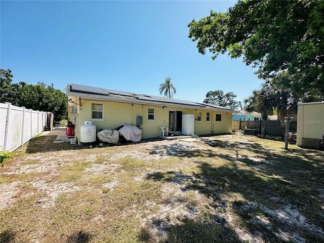 1101 Alcazar Way S, Saint Petersburg, FL 33705 - back of property featuring roof mounted solar panels, central AC unit, and a fenced backyard