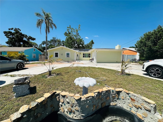 1101 Alcazar Way S, Saint Petersburg, FL 33705 - view of front of house featuring concrete driveway, solar panels, and a front yard