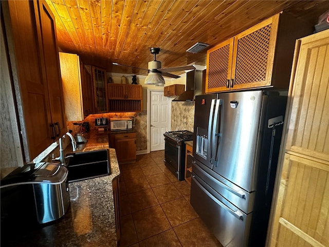 1101 Alcazar Way S, Saint Petersburg, FL 33705 - kitchen with stainless steel refrigerator with ice dispenser, dark tile patterned floors, wall chimney exhaust hood, a sink, and gas stove