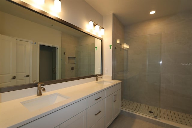 bathroom featuring a sink, a stall shower, recessed lighting, and double vanity