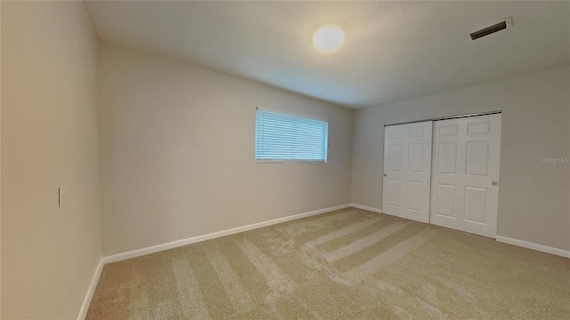 unfurnished bedroom featuring baseboards, carpet flooring, and visible vents