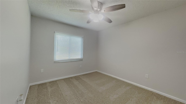carpeted spare room featuring a ceiling fan, baseboards, and a textured ceiling