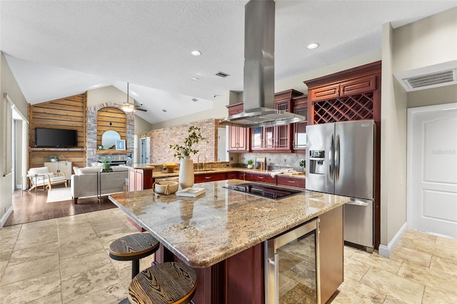 4690 Wrentham Pl, Palm Harbor, FL 34685 - kitchen with stainless steel refrigerator with ice dispenser, beverage cooler, island exhaust hood, reddish brown cabinets, and light stone countertops