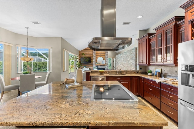 4690 Wrentham Pl, Palm Harbor, FL 34685 - kitchen with stainless steel appliances, island range hood, reddish brown cabinets, light stone counters, and a peninsula